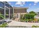 Exterior showcasing a well-maintained side yard with a variety of plants and access to a screened patio at 5702 Tides Pl, Apollo Beach, FL 33572