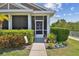 Charming home entrance featuring a screened porch and lush, landscaped surroundings at 5702 Tides Pl, Apollo Beach, FL 33572
