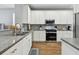 Modern kitchen featuring white cabinetry, granite countertops, stainless steel appliances, and stylish backsplash at 5702 Tides Pl, Apollo Beach, FL 33572
