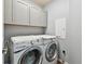 Laundry room featuring modern washer and dryer, with white cabinets above for ample storage and organization at 5702 Tides Pl, Apollo Beach, FL 33572