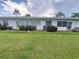 Backyard with trimmed grass and white siding home at 605 Brandy Wine Dr # 605, Largo, FL 33771