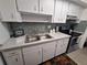 Bright kitchen features white cabinets, stainless steel appliances, and tiled backsplash at 605 Brandy Wine Dr # 605, Largo, FL 33771