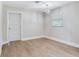 Empty bedroom features light wood floors, an updated light fixture, and a window for natural light at 623 15Th Nw Ave, Largo, FL 33770