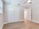 Bright bedroom has a ceiling fan, light wood floors, and a large closet with sliding doors at 623 15Th Nw Ave, Largo, FL 33770