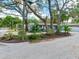 Street view of a gray home with tropical landscaping, mature trees and well-manicured lawn at 623 15Th Nw Ave, Largo, FL 33770