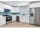 Bright kitchen features stainless steel appliances, white cabinets, and a blue backsplash for a modern design at 623 15Th Nw Ave, Largo, FL 33770