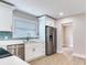 The renovated kitchen features stainless steel appliances, bright white cabinets, and new hardwood floors at 623 15Th Nw Ave, Largo, FL 33770