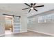 Bright main bedroom featuring a ceiling fan, hardwood floors and a stylishly designed barn door to the bathroom at 623 15Th Nw Ave, Largo, FL 33770
