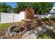 Picturesque backyard with a brick grill, fish pond, white fence, and storage shed at 6801 5Th N St, St Petersburg, FL 33702