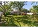 Expansive backyard featuring lush green grass, mature trees, and a wooden deck at 6801 5Th N St, St Petersburg, FL 33702