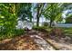 Landscaped backyard with brick path, mature trees, and a white fence at 6801 5Th N St, St Petersburg, FL 33702