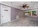 Living room with neutral gray walls, a ceiling fan, tiled floor, and natural light from the window at 6801 5Th N St, St Petersburg, FL 33702