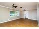 Inviting living room with neutral walls, tile flooring, ceiling fans and ample natural light from a large window at 6801 5Th N St, St Petersburg, FL 33702