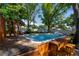 Backyard featuring an in-ground pool with surrounding deck and mature trees at 6801 5Th N St, St Petersburg, FL 33702