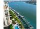 Stunning aerial view of a condo building adjacent to a waterfront with boat docks and lush landscaping at 690 Island Way # 707, Clearwater Beach, FL 33767