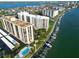 Aerial view of waterfront condominiums with boat docks, swimming pool, and lush landscaping offering scenic views at 690 Island Way # 707, Clearwater Beach, FL 33767