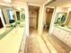 Well-lit bathroom has double sinks, tiled floors, and separate shower and toilet rooms at 690 Island Way # 707, Clearwater Beach, FL 33767