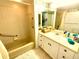 Bright bathroom featuring a tiled tub, white vanity with sink, and decorative seashell wallpaper border at 690 Island Way # 707, Clearwater Beach, FL 33767