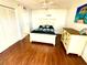 A bedroom with white walls, wooden floors, closet, and a tropical print on the wall at 690 Island Way # 707, Clearwater Beach, FL 33767