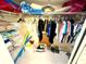A walk-in closet with shelving, hanging clothes, and various personal items at 690 Island Way # 707, Clearwater Beach, FL 33767