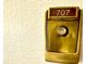 Close-up view of the apartment door with vintage hardware and building unit number at 690 Island Way # 707, Clearwater Beach, FL 33767