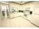 Well-lit kitchen features white cabinetry, matching appliances, and a view of the living area at 690 Island Way # 707, Clearwater Beach, FL 33767