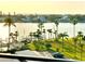 Water view of waterfront property with tropical palm trees, docks, and boats on the horizon at 690 Island Way # 707, Clearwater Beach, FL 33767