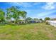 Large backyard featuring a sprawling lawn, mature trees, and chain-link fencing for added privacy at 7041 Lexington Cir, Brooksville, FL 34602