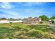 Expansive backyard featuring a lush lawn, mature landscaping, and a cozy firepit perfect for outdoor entertaining at 7041 Lexington Cir, Brooksville, FL 34602