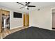Bedroom with wood floors, ceiling fan, TV, and a door to the walk-in closet at 7041 Lexington Cir, Brooksville, FL 34602