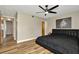 Bedroom featuring wood floors, a black bed set, ceiling fan, and a doorway to other rooms at 7041 Lexington Cir, Brooksville, FL 34602
