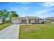 Inviting single-story home with a green lawn, attached garage, and meticulously kept landscaping at 7041 Lexington Cir, Brooksville, FL 34602