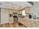 Well-lit kitchen with stainless steel appliances, wood-look cabinetry, and stylish backsplash at 7041 Lexington Cir, Brooksville, FL 34602