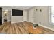 Bright living room featuring wood-look floors and a large mounted TV at 7041 Lexington Cir, Brooksville, FL 34602