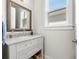 Bright bathroom features a white vanity with marble countertop and a wood-framed mirror at 8580 Ivy Stark Blvd, Wesley Chapel, FL 33545