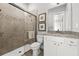 Modern bathroom with a tiled walk-in shower, granite countertop, and white vanity at 8580 Ivy Stark Blvd, Wesley Chapel, FL 33545