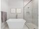 Bright bathroom showcasing soaking tub, glass shower with mosaic tile, and decorative wall art at 8580 Ivy Stark Blvd, Wesley Chapel, FL 33545