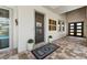 A covered front entry features decorative plants, modern door and neutral decor at 8580 Ivy Stark Blvd, Wesley Chapel, FL 33545