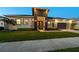 Beautiful home exterior with modern design elements, manicured lawn and garden, and a two-car garage at 8580 Ivy Stark Blvd, Wesley Chapel, FL 33545