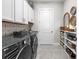 Well-organized laundry room with modern washer/dryer, stylish tile backsplash, and storage shelves at 8580 Ivy Stark Blvd, Wesley Chapel, FL 33545