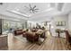 Bright open-concept living room featuring elegant furniture, wood flooring, high ceilings, and sliding glass doors at 8580 Ivy Stark Blvd, Wesley Chapel, FL 33545