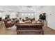Large open living area featuring leather furniture, a ceiling fan, and luxury vinyl plank flooring at 8580 Ivy Stark Blvd, Wesley Chapel, FL 33545