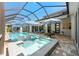 Stunning screened-in pool area with ample seating, spa, and a luxurious patio at 8580 Ivy Stark Blvd, Wesley Chapel, FL 33545