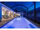 Sparkling swimming pool with spa and screened enclosure and lounge chairs in the backyard at 8580 Ivy Stark Blvd, Wesley Chapel, FL 33545