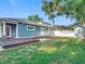 Backyard with a wood deck, grassy area, modern storage shed, and a partial view of the screened pool at 917 W Alfred St, Tampa, FL 33603
