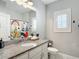 Bathroom featuring a granite countertop, modern fixtures, a decorative shower curtain, and shuttered windows at 917 W Alfred St, Tampa, FL 33603