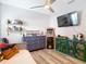 Spacious bedroom with a ceiling fan, displaying helmets on shelves, a TV, and a vintage arcade game at 917 W Alfred St, Tampa, FL 33603