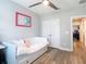 Bedroom with pull-out trundle bed, colorful art, a ceiling fan, and an open doorway at 917 W Alfred St, Tampa, FL 33603