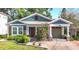 Charming home featuring a brick driveway, red door, and colorful landscaping, with inviting curb appeal at 917 W Alfred St, Tampa, FL 33603