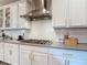 Kitchen with white subway tile backsplash, modern gas range, and sleek stainless steel vent hood at 917 W Alfred St, Tampa, FL 33603